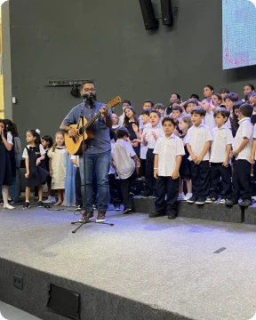 Alunos da Zoe em celebração com música ao vivo