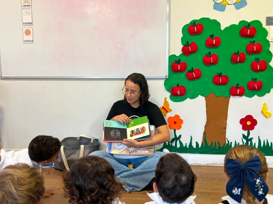 Professora lendo para os alunos da Zoe