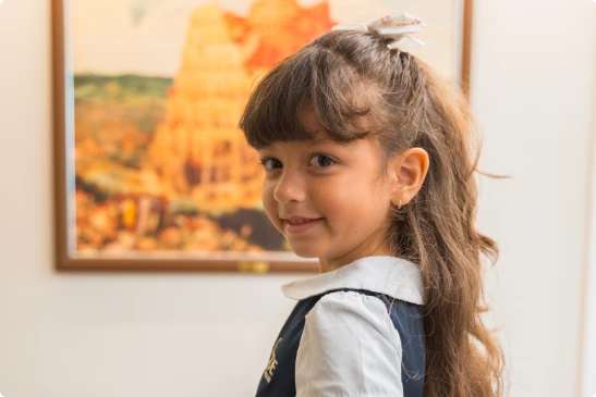 Aluna da Zoe sorrindo em sala de aula