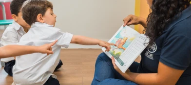 Professora lendo um livro com alunos da Zoe